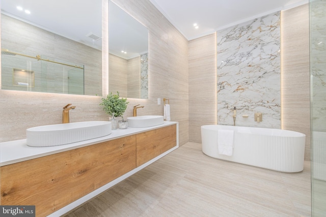 bathroom with vanity, tile walls, and shower with separate bathtub