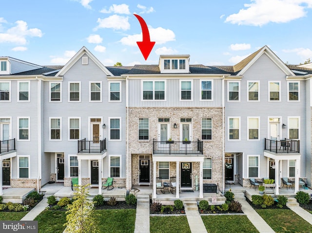 view of front of house with a balcony and a patio