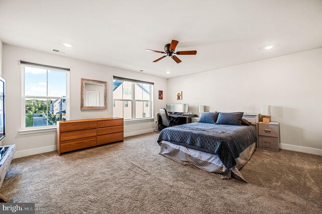 bedroom featuring ceiling fan, carpet floors, and multiple windows