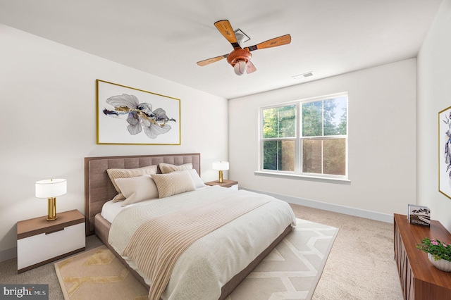 bedroom with baseboards, visible vents, a ceiling fan, and light colored carpet