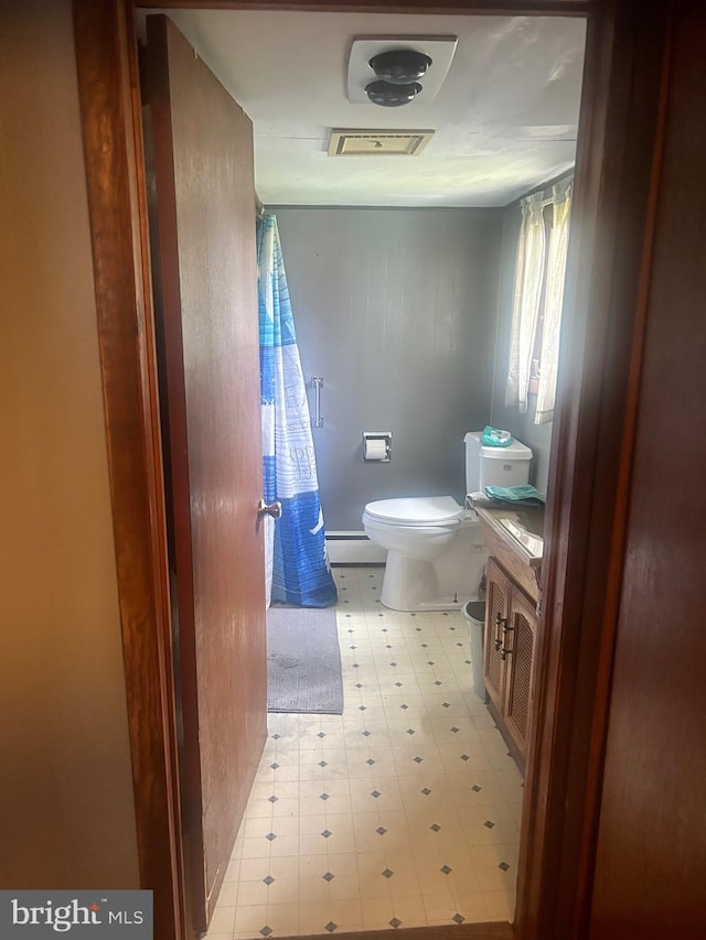 bathroom with a baseboard heating unit, toilet, and vanity