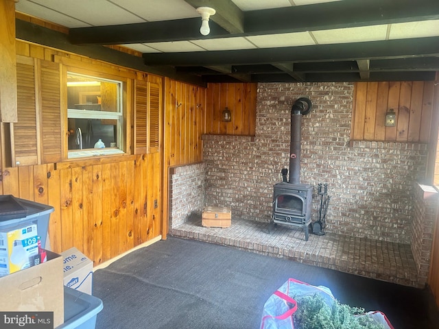 kitchen with wood walls, dark colored carpet, and a wood stove