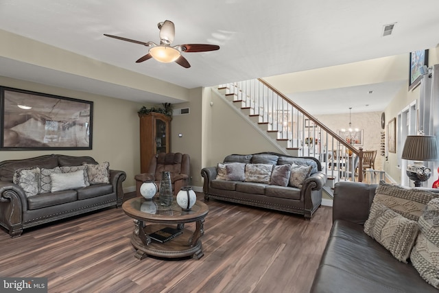 living room featuring ceiling fan with notable chandelier and dark hardwood / wood-style flooring