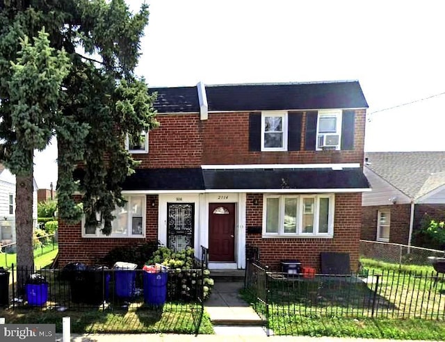 townhome / multi-family property featuring a front yard and cooling unit