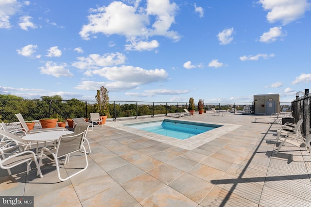 view of swimming pool featuring fence, a fenced in pool, and a patio