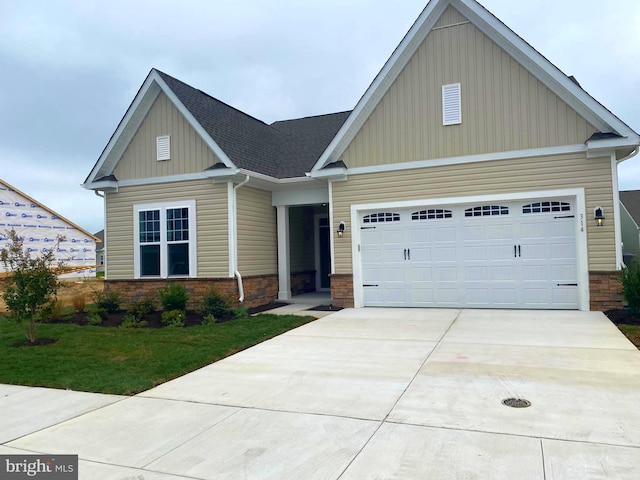 craftsman house with a front yard and a garage