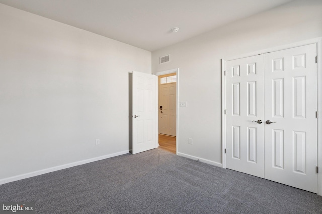 unfurnished bedroom featuring baseboards, a closet, visible vents, and carpet flooring