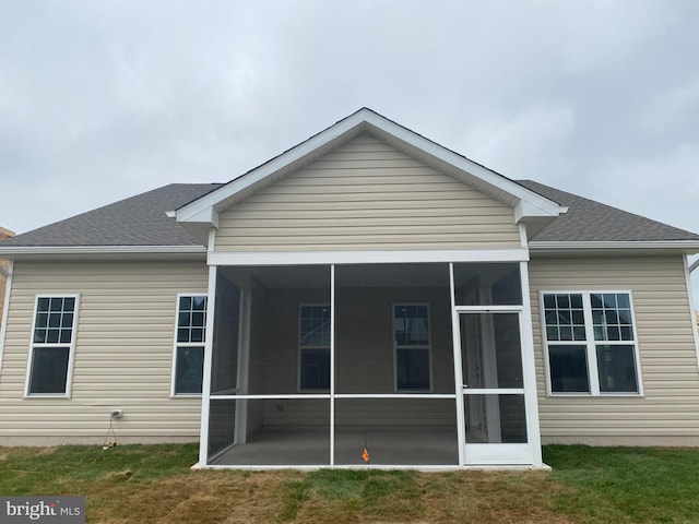 rear view of house with a yard and a sunroom