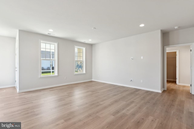 unfurnished room featuring light wood-type flooring, baseboards, and recessed lighting