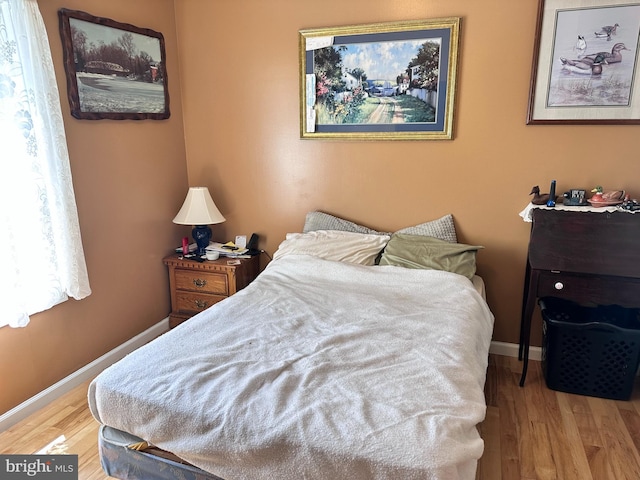 bedroom featuring wood finished floors and baseboards