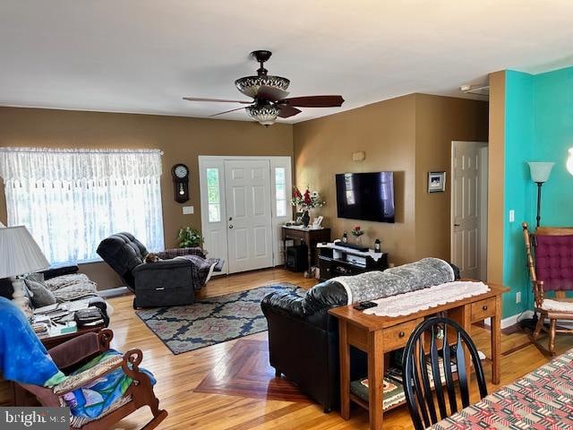 living room with light wood-type flooring and ceiling fan