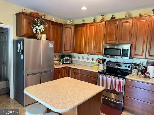 kitchen with a center island, stainless steel appliances, and decorative backsplash