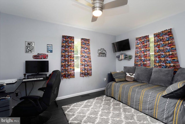 bedroom with ceiling fan, wood finished floors, visible vents, and baseboards