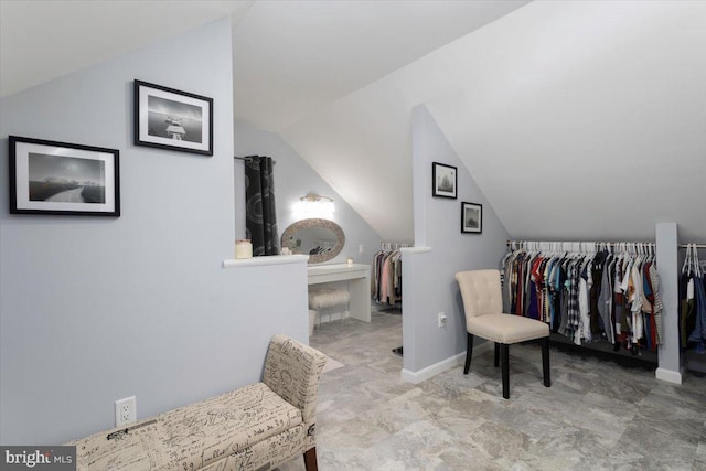 interior space with vaulted ceiling and baseboards