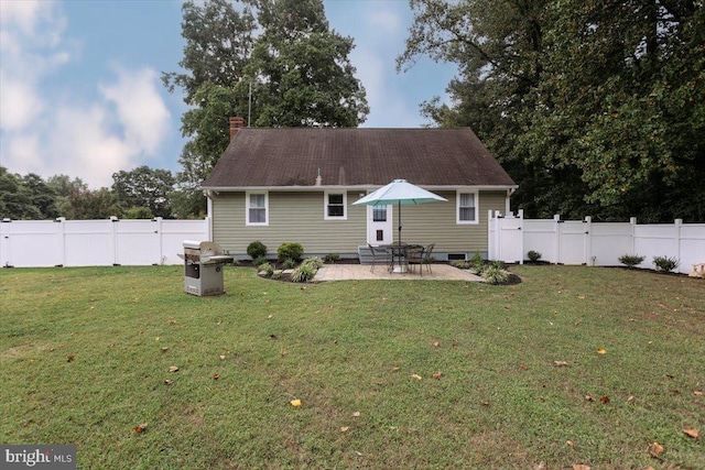 rear view of house with a yard, a gate, a fenced backyard, and a patio