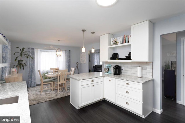 kitchen with dark wood-style flooring, open shelves, backsplash, white cabinets, and a peninsula