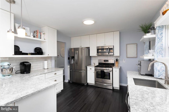 kitchen featuring stainless steel appliances, open shelves, a sink, and white cabinets