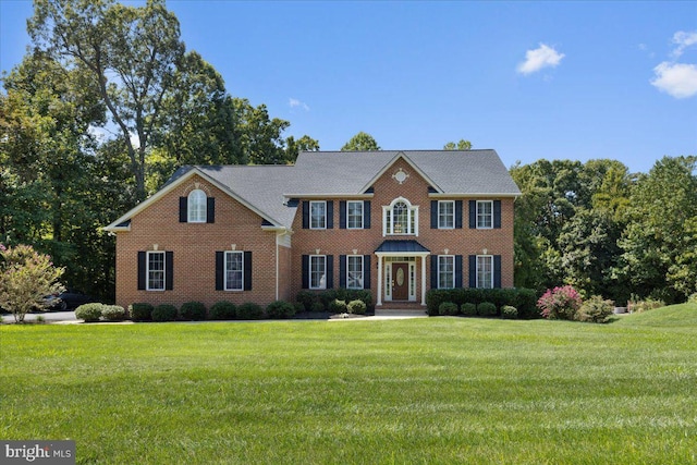 colonial-style house featuring a front yard