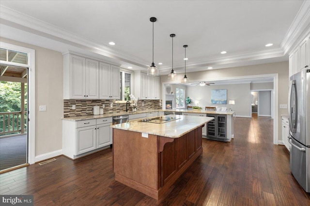 kitchen featuring appliances with stainless steel finishes, a center island, white cabinetry, and dark wood-type flooring