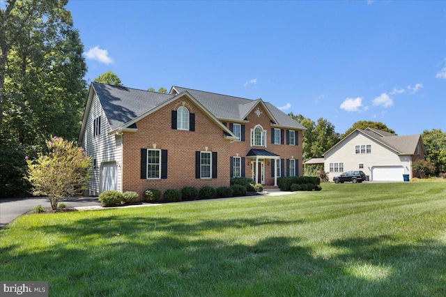 colonial home featuring a front lawn and a garage