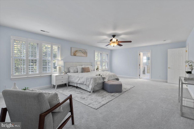 bedroom with connected bathroom, ceiling fan, and light colored carpet