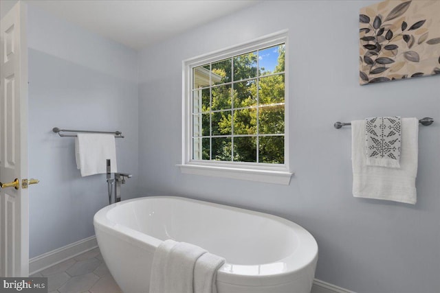 bathroom with tile patterned floors and a tub