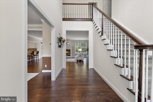 entryway with dark hardwood / wood-style flooring and crown molding