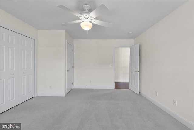 unfurnished bedroom featuring a closet, ceiling fan, and light colored carpet