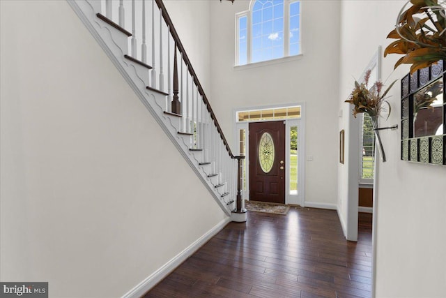 foyer entrance with dark wood-type flooring and a high ceiling