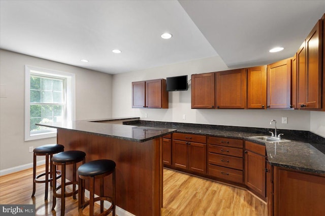 kitchen featuring a breakfast bar, light hardwood / wood-style floors, and sink