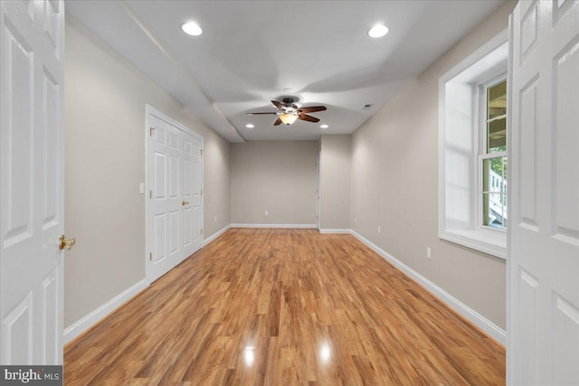 empty room with ceiling fan and light hardwood / wood-style floors