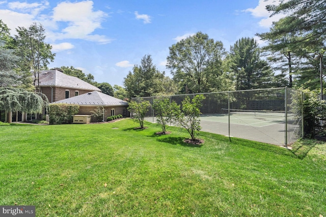 view of tennis court with a yard