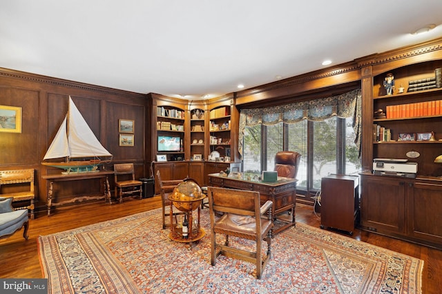 office area featuring ornamental molding, wood walls, hardwood / wood-style floors, and built in features