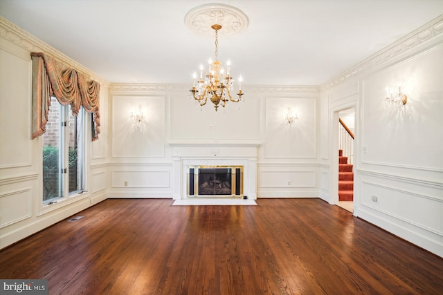 unfurnished living room with ornamental molding, a chandelier, and dark wood-type flooring