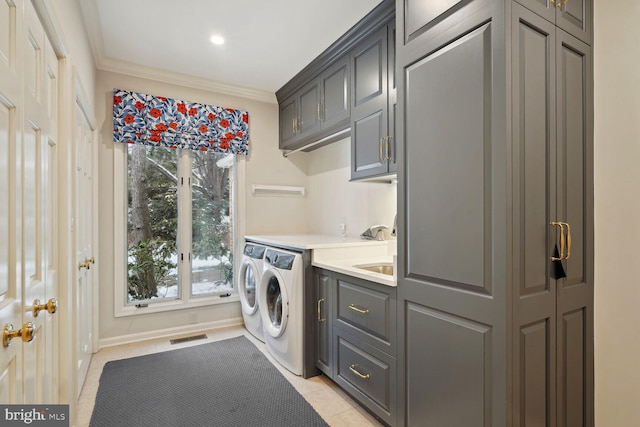 laundry area with cabinets, independent washer and dryer, light tile patterned floors, and crown molding