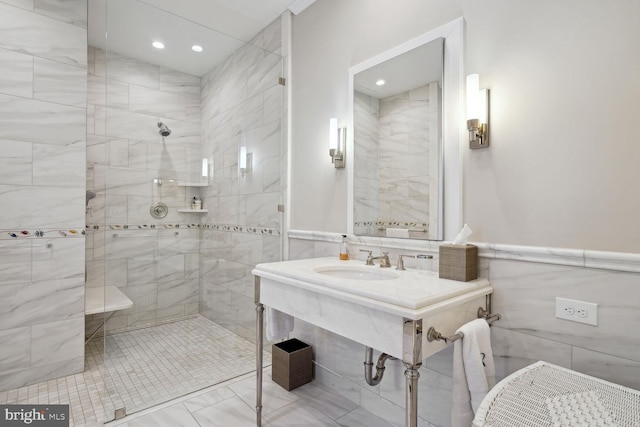 bathroom featuring tile walls, sink, and tiled shower