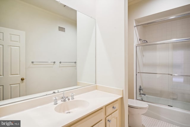 full bathroom with tile patterned flooring, shower / bath combination with glass door, vanity, and toilet