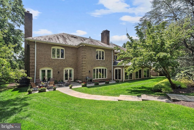 rear view of property with a patio and a yard