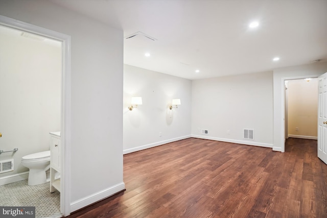 interior space with dark wood-type flooring and ensuite bathroom