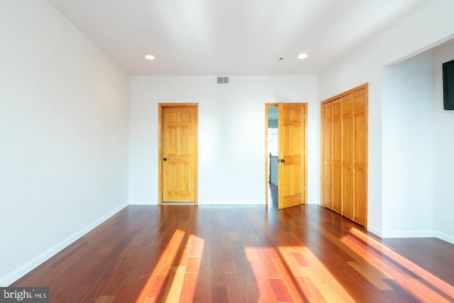 unfurnished bedroom featuring dark wood-type flooring and a closet