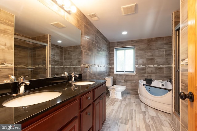 full bathroom with tile walls, toilet, vanity, and plus walk in shower