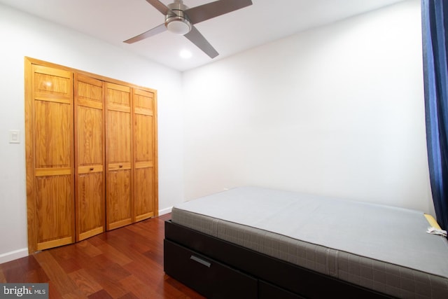 bedroom featuring dark wood-type flooring, ceiling fan, and a closet