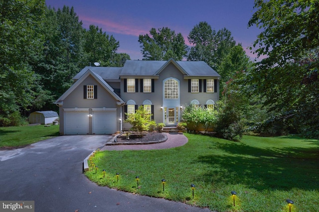 colonial-style house with a yard and a garage