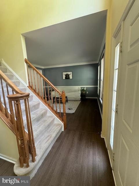 foyer featuring dark wood finished floors, stairway, and baseboards