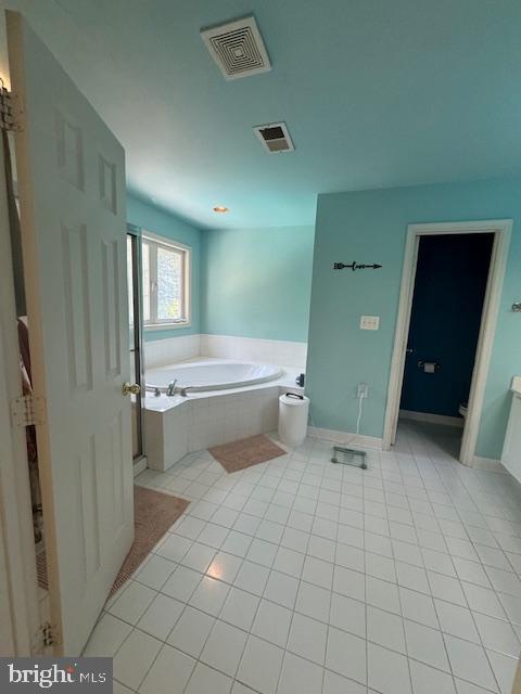 full bath featuring a garden tub, toilet, tile patterned flooring, and visible vents