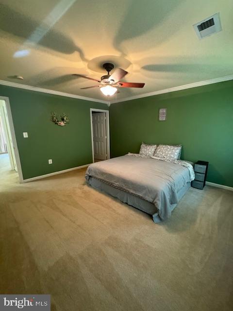 bedroom with carpet, a closet, visible vents, and crown molding