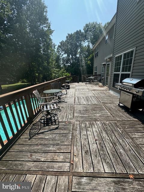 deck with outdoor dining space and grilling area