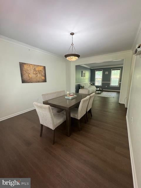 dining area featuring ornamental molding, dark wood-type flooring, and baseboards