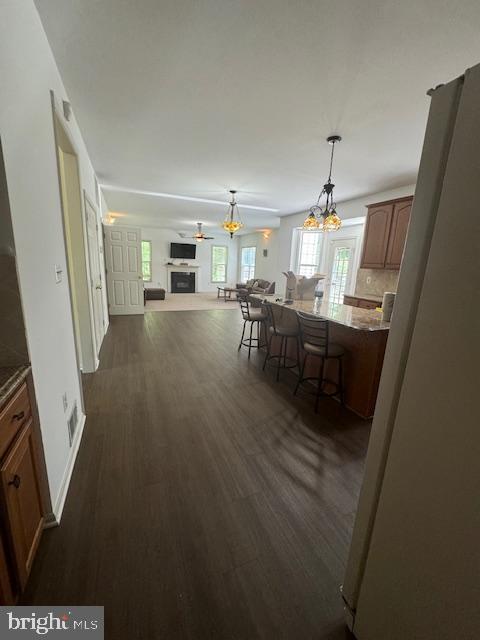 dining area featuring a fireplace, baseboards, and dark wood finished floors