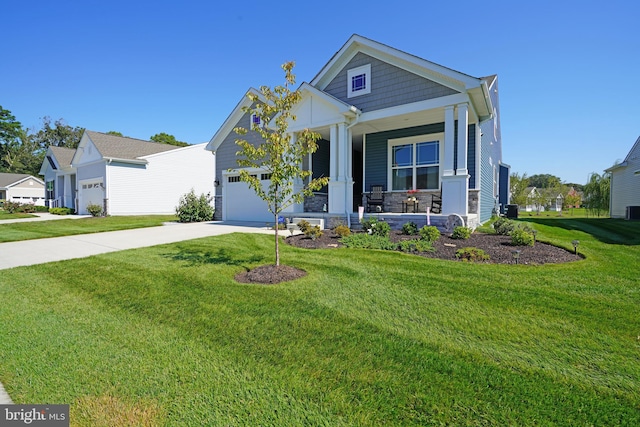 view of front facade with a garage, a front lawn, and covered porch